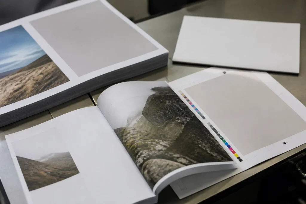 A5 booklet proof and pages being checked before print approval.